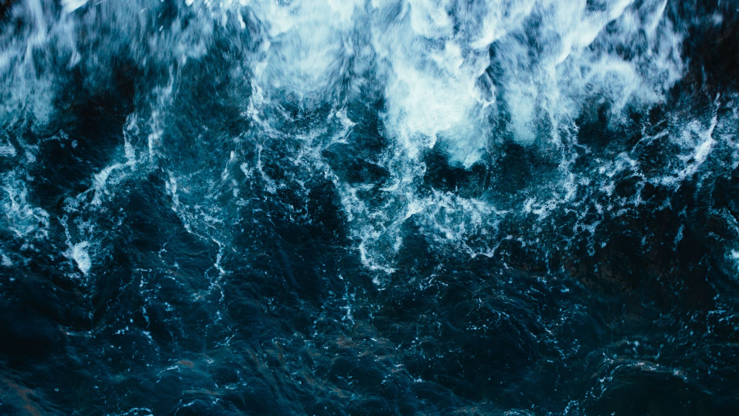 Ocean waves crashing over dark water, evoking the coastal atmosphere of Neptune City, NJ, aligned with Shipwreck'd cannabis dispensary's community connection and natural essence.