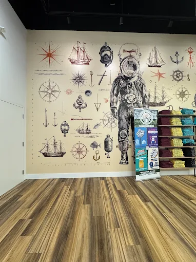 Coastal-themed interior with nautical mural and product display at Neptune City's Shipwreck’d dispensary.